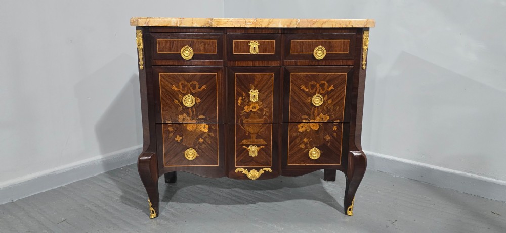 A French Louis XV style marquetry commode chest featuring floral inlays, gilt-bronze mounts, cabriole legs, and a beige marble top. View III