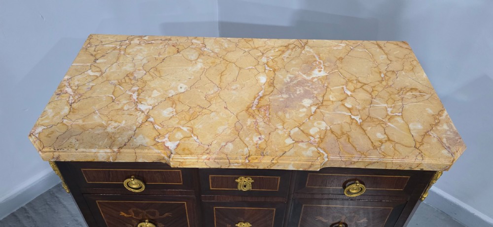 A French Louis XV style marquetry commode chest featuring floral inlays, gilt-bronze mounts, cabriole legs, and a beige marble top. View IX