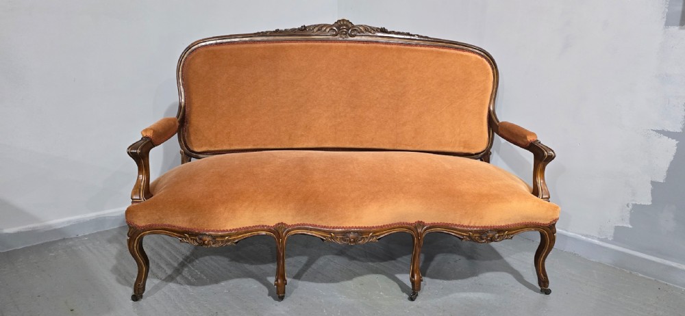 A French Louis XV style carved walnut settee with warm amber velvet upholstery, serpentine seat rail, and cabriole legs. View V