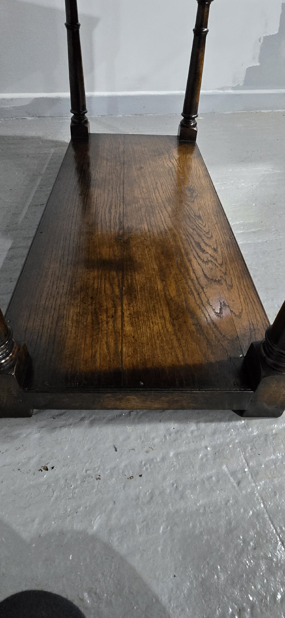 An antique dark oak dresser base featuring four panelled drawers with brass drop handles above turned supports and an open lower shelf. View XVII