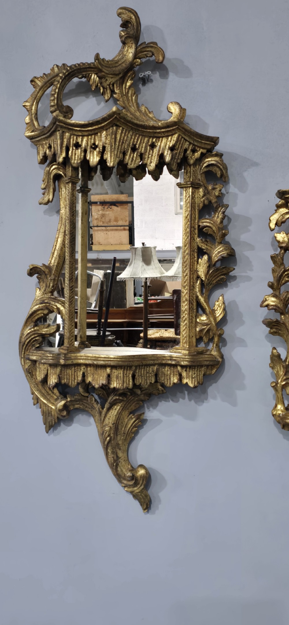 A pair of carved giltwood wall mirrors featuring Chinese Chippendale pagoda crestings and Rococo C-scroll motifs. View III