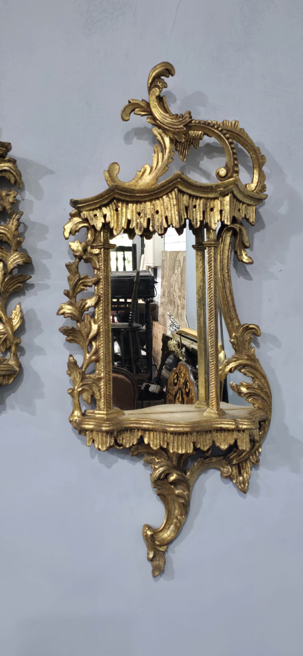 A pair of carved giltwood wall mirrors featuring Chinese Chippendale pagoda crestings and Rococo C-scroll motifs. View IV