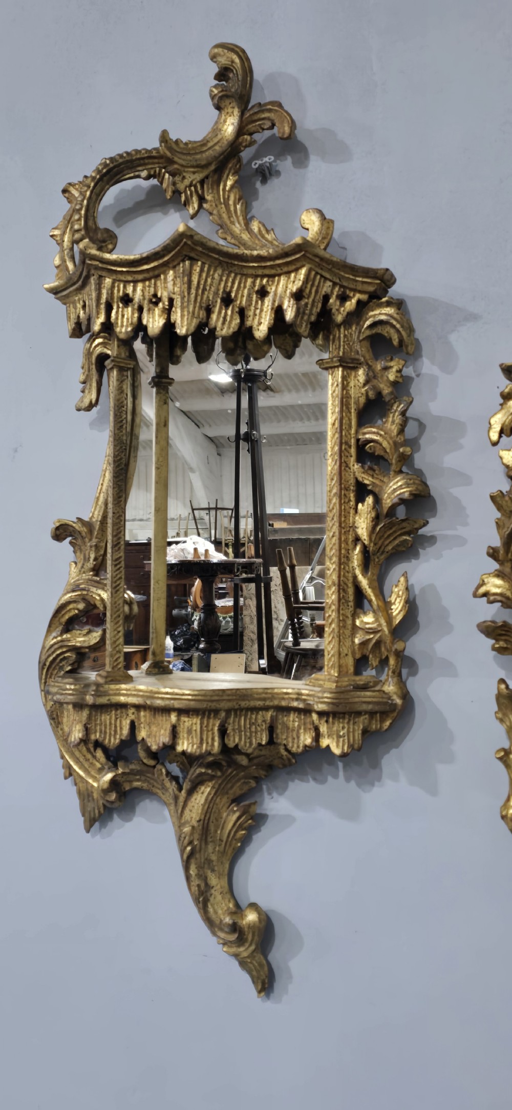 A pair of carved giltwood wall mirrors featuring Chinese Chippendale pagoda crestings and Rococo C-scroll motifs. View V