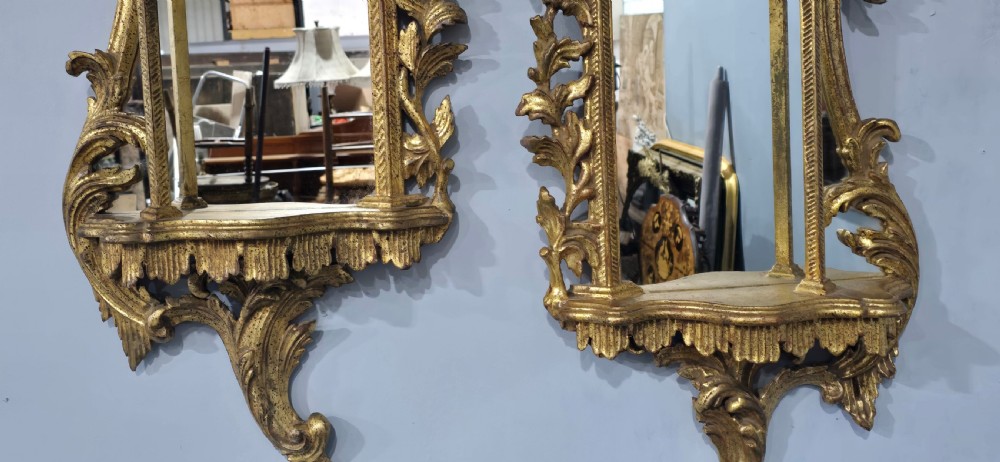 A pair of carved giltwood wall mirrors featuring Chinese Chippendale pagoda crestings and Rococo C-scroll motifs. View VII