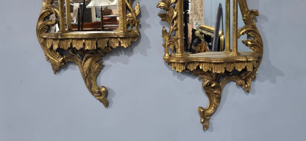 A pair of carved giltwood wall mirrors featuring Chinese Chippendale pagoda crestings and Rococo C-scroll motifs. View VIII
