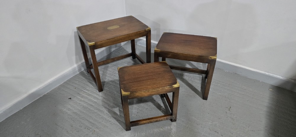 A set of three graduated mahogany nest tables with brass corner mounts and central plaque inlays stacked on straight square legs. View V