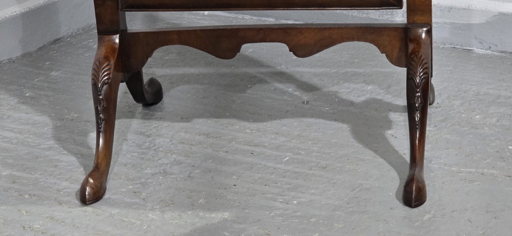 A full-length antique walnut cheval mirror featuring an arched top frame, turned vertical supports with finials, and carved cabriole legs. View VII