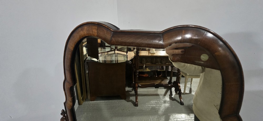 A full-length antique walnut cheval mirror featuring an arched top frame, turned vertical supports with finials, and carved cabriole legs. View X