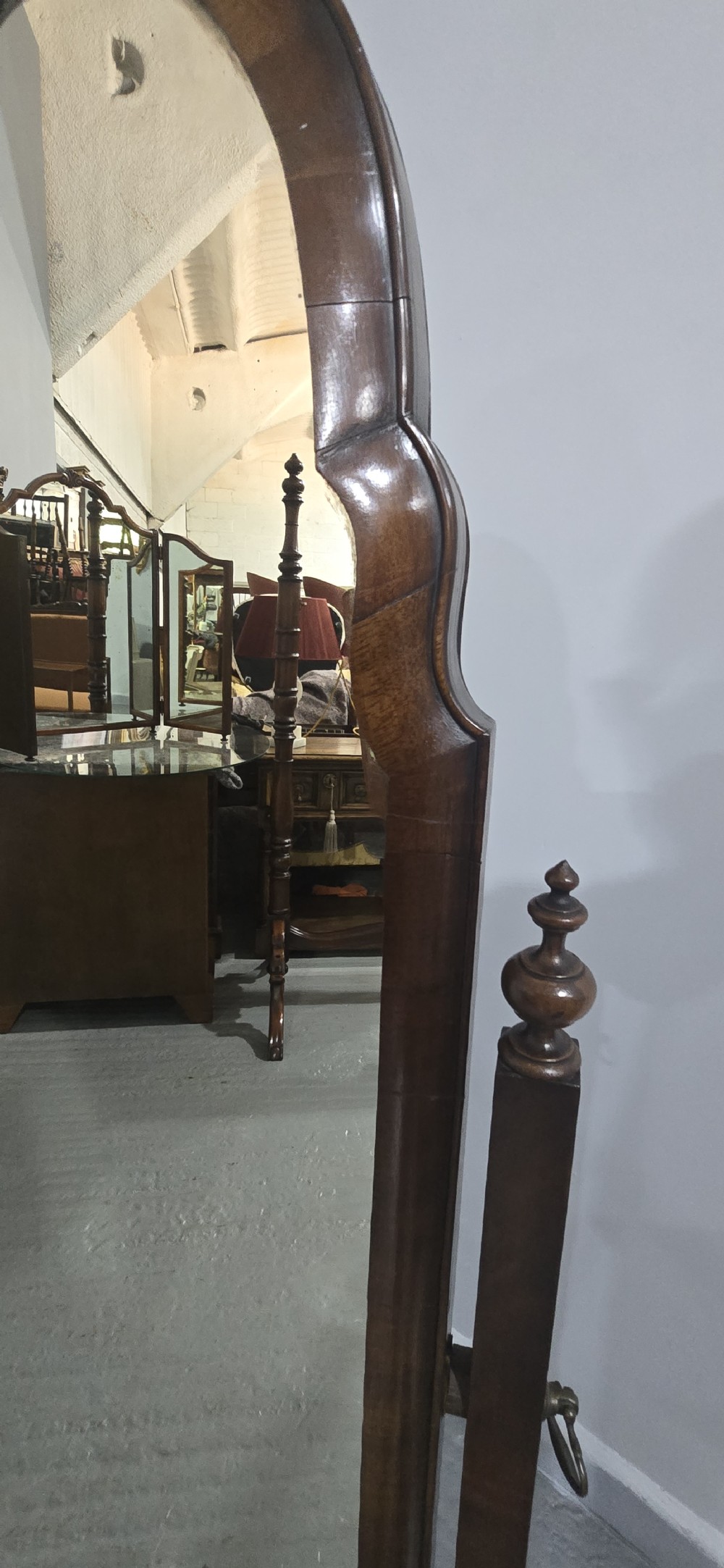 A full-length antique walnut cheval mirror featuring an arched top frame, turned vertical supports with finials, and carved cabriole legs. View XI