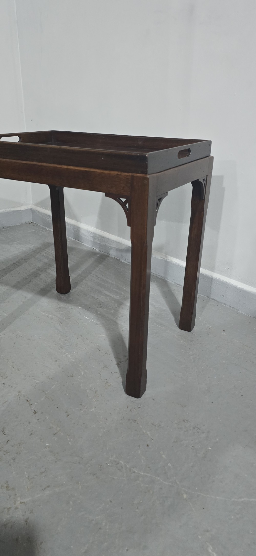 A pair of dark mahogany rectangular lamp tables featuring tray tops with cut-out handles and decorative fretwork corner brackets on straight legs. View IV