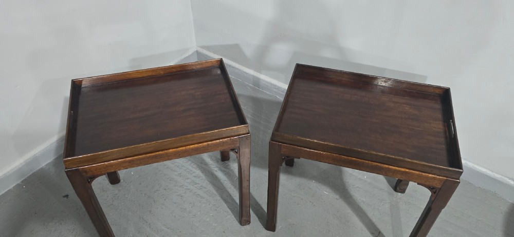 A pair of dark mahogany rectangular lamp tables featuring tray tops with cut-out handles and decorative fretwork corner brackets on straight legs. View V