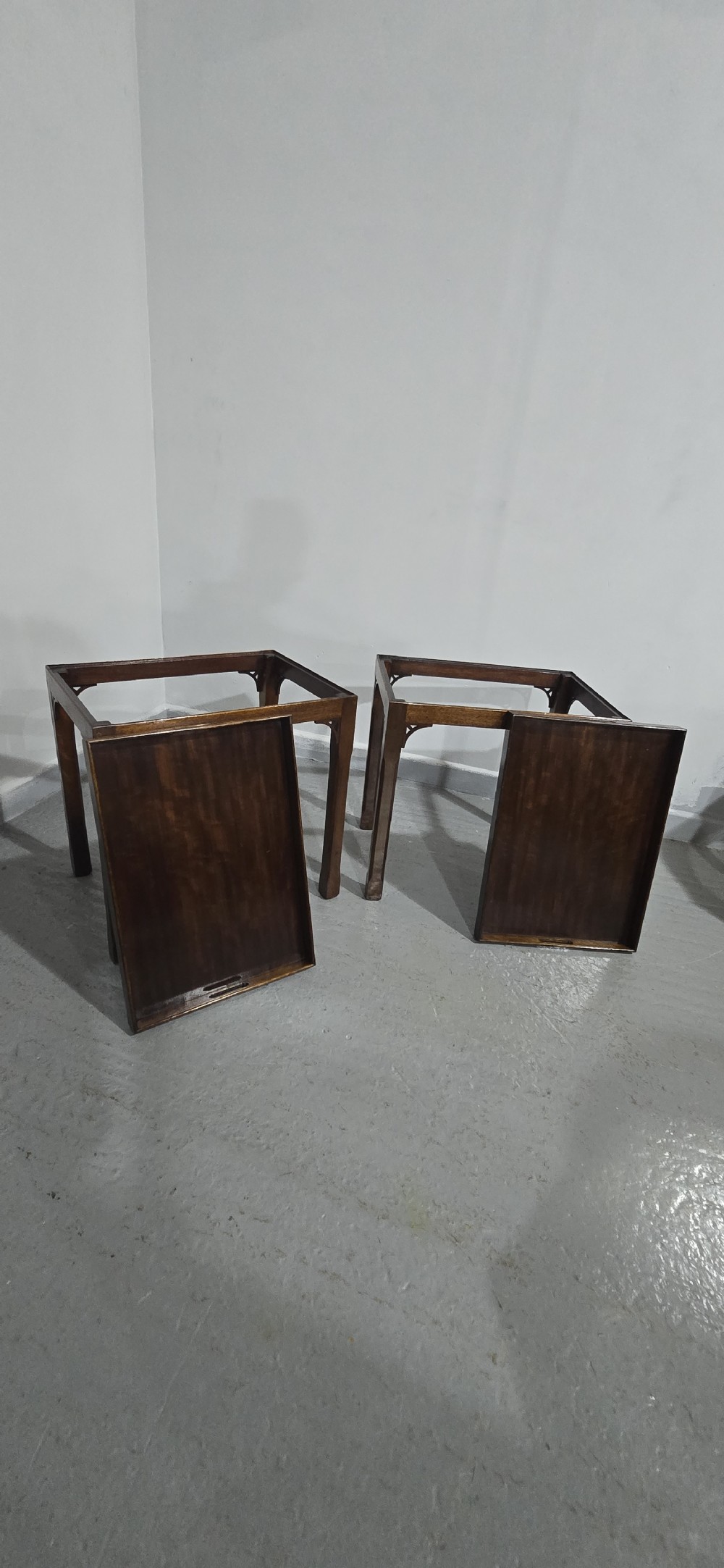 A pair of dark mahogany rectangular lamp tables featuring tray tops with cut-out handles and decorative fretwork corner brackets on straight legs. View VII