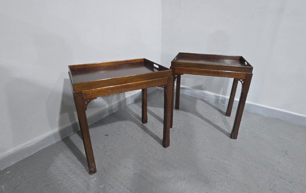 A pair of dark mahogany rectangular lamp tables featuring tray tops with cut-out handles and decorative fretwork corner brackets on straight legs. View X