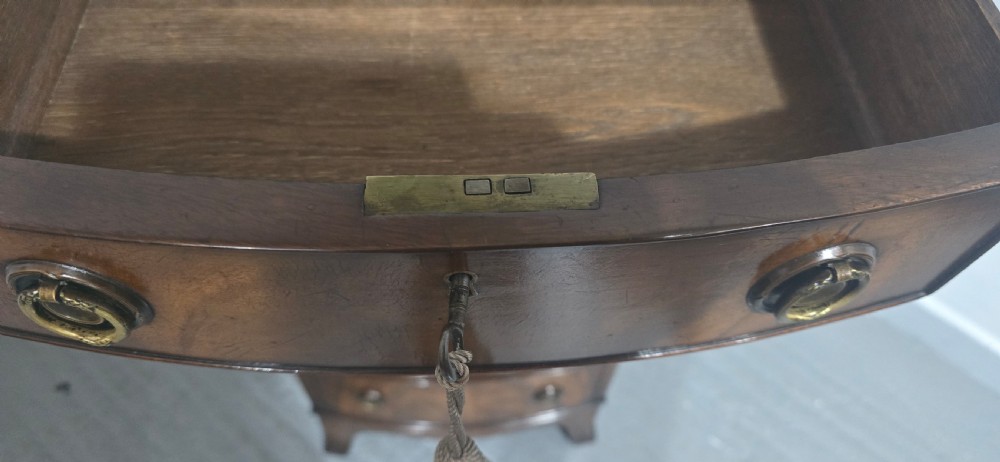 A tall Regency mahogany bowfront chest of drawers featuring six graduated drawers with ring pull handles and bracket feet. View V