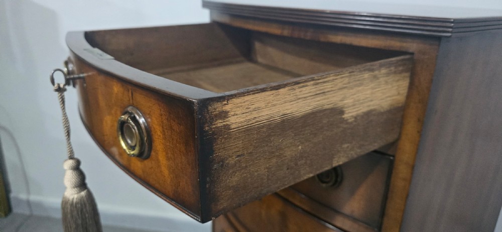 A tall Regency mahogany bowfront chest of drawers featuring six graduated drawers with ring pull handles and bracket feet. View VI