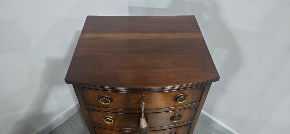 A tall Regency mahogany bowfront chest of drawers featuring six graduated drawers with ring pull handles and bracket feet. View X