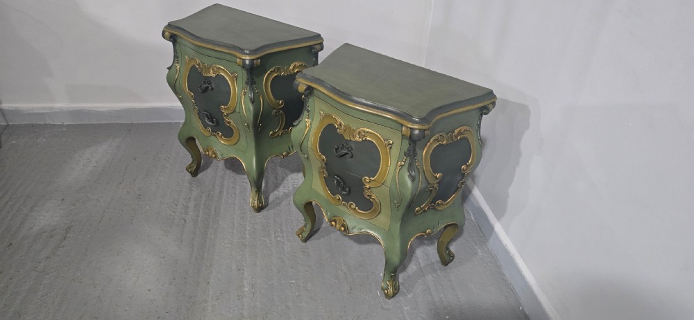 A pair of sage green and gold painted French Louis XV style bedside chests featuring bombee sides, cabriole legs, and ornate scroll moulding. View IV