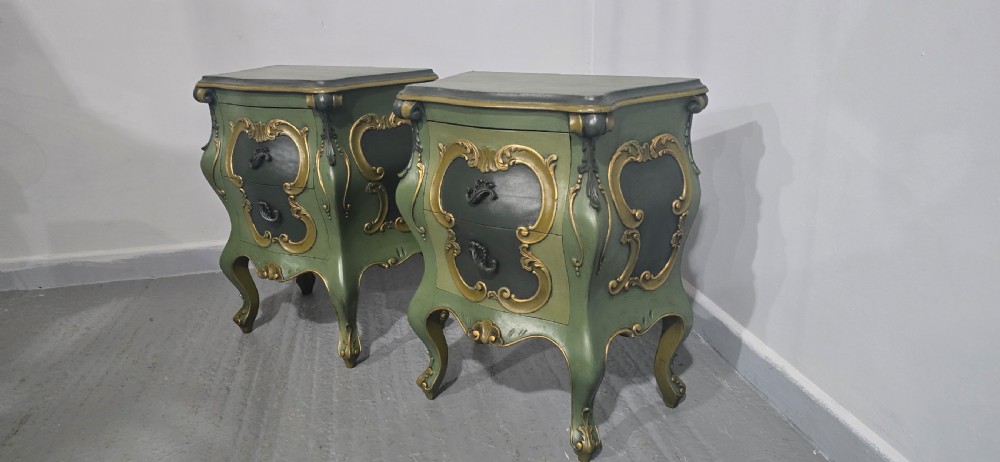A pair of sage green and gold painted French Louis XV style bedside chests featuring bombee sides, cabriole legs, and ornate scroll moulding. View V