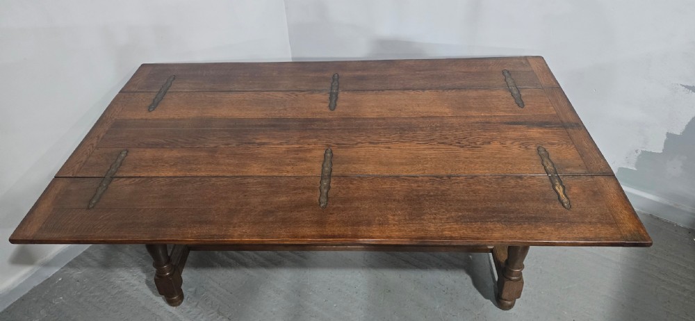 A long rectangular dark oak refectory dining table featuring turned wooden legs, a central stretcher, and a plank top. View VI