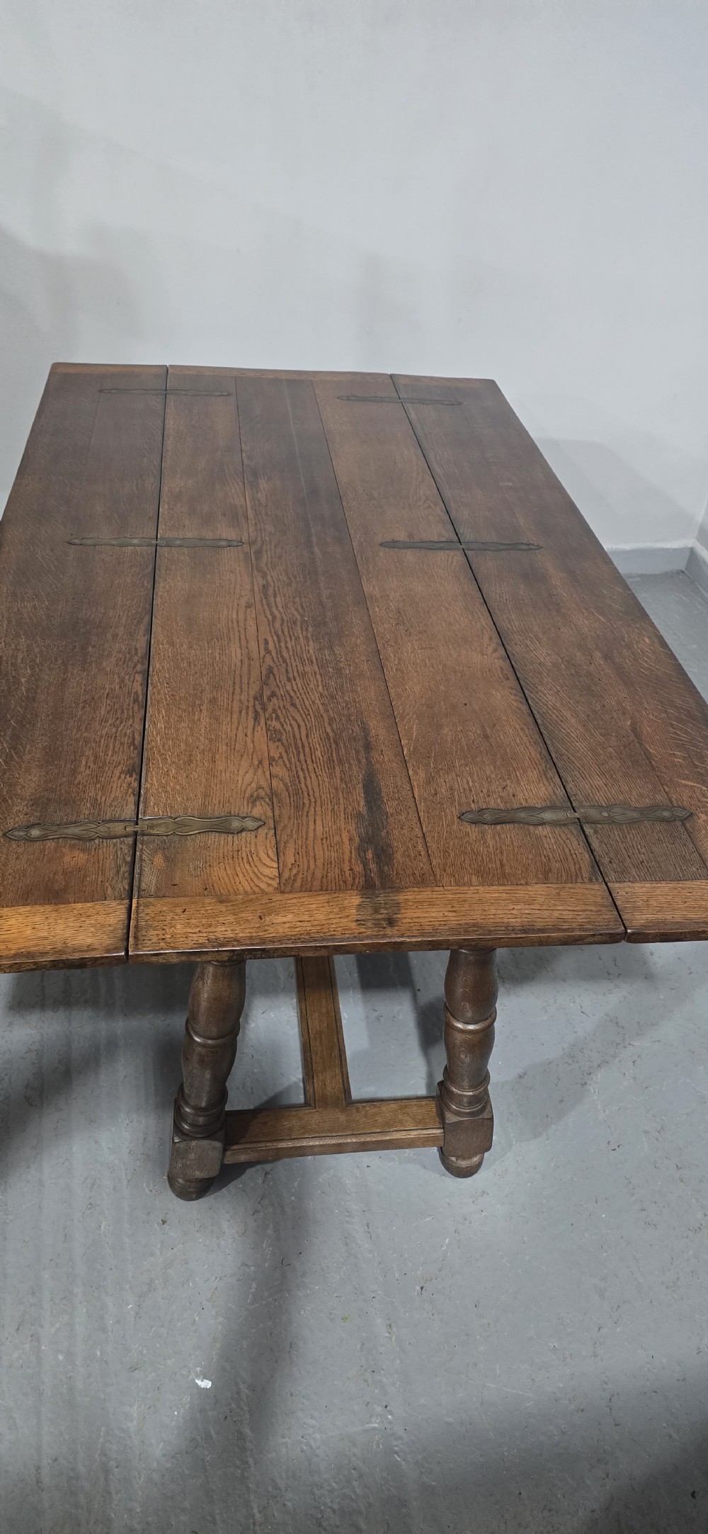 A long rectangular dark oak refectory dining table featuring turned wooden legs, a central stretcher, and a plank top. View VIII