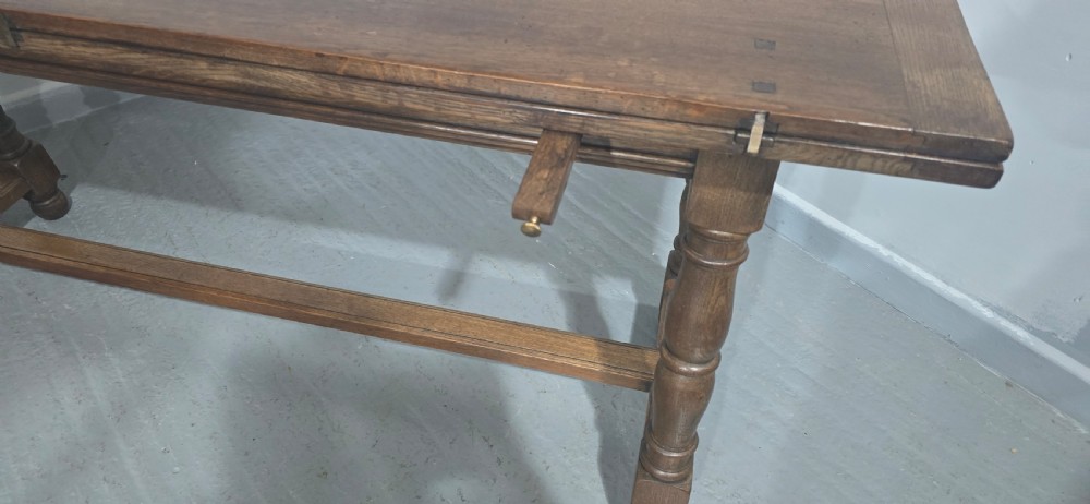 A long rectangular dark oak refectory dining table featuring turned wooden legs, a central stretcher, and a plank top. View XIII
