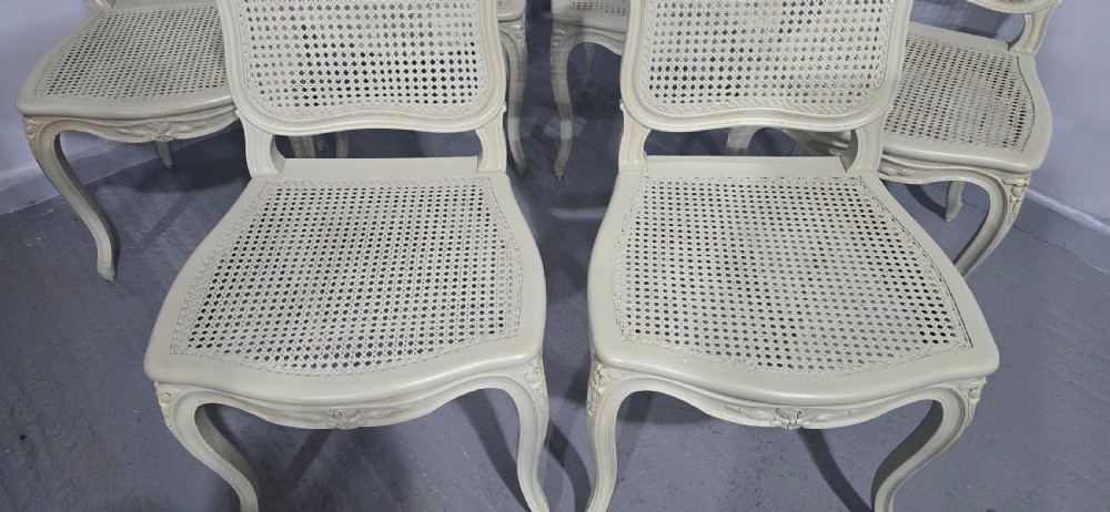 A set of six French-style dining chairs painted in pale grey with woven cane backrests, cane seats, and carved cabriole legs. View III