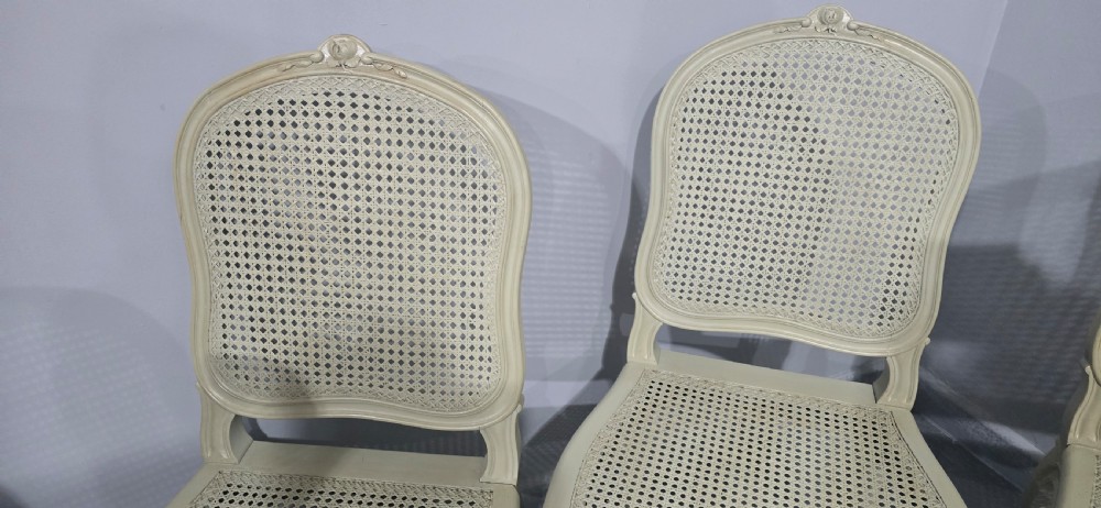 A set of six French-style dining chairs painted in pale grey with woven cane backrests, cane seats, and carved cabriole legs. View VII