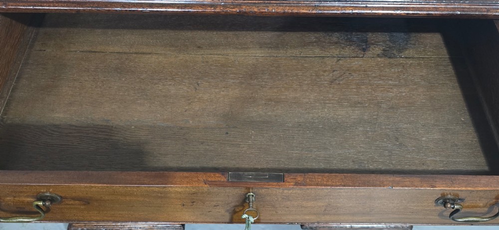A Georgian mahogany kneehole desk featuring a long top drawer, six side drawers, a central recessed cupboard, brass swan-neck handles, and bracket feet. View IX