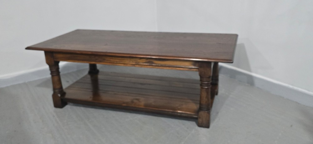 A rectangular dark oak coffee table featuring a plank top, turned legs, and a lower slatted shelf. View III