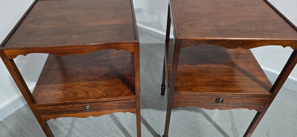 A pair of Georgian mahogany bedside tables featuring square tray tops, open upper shelves, single drawers with brass ring handles, and square tapered legs. View V