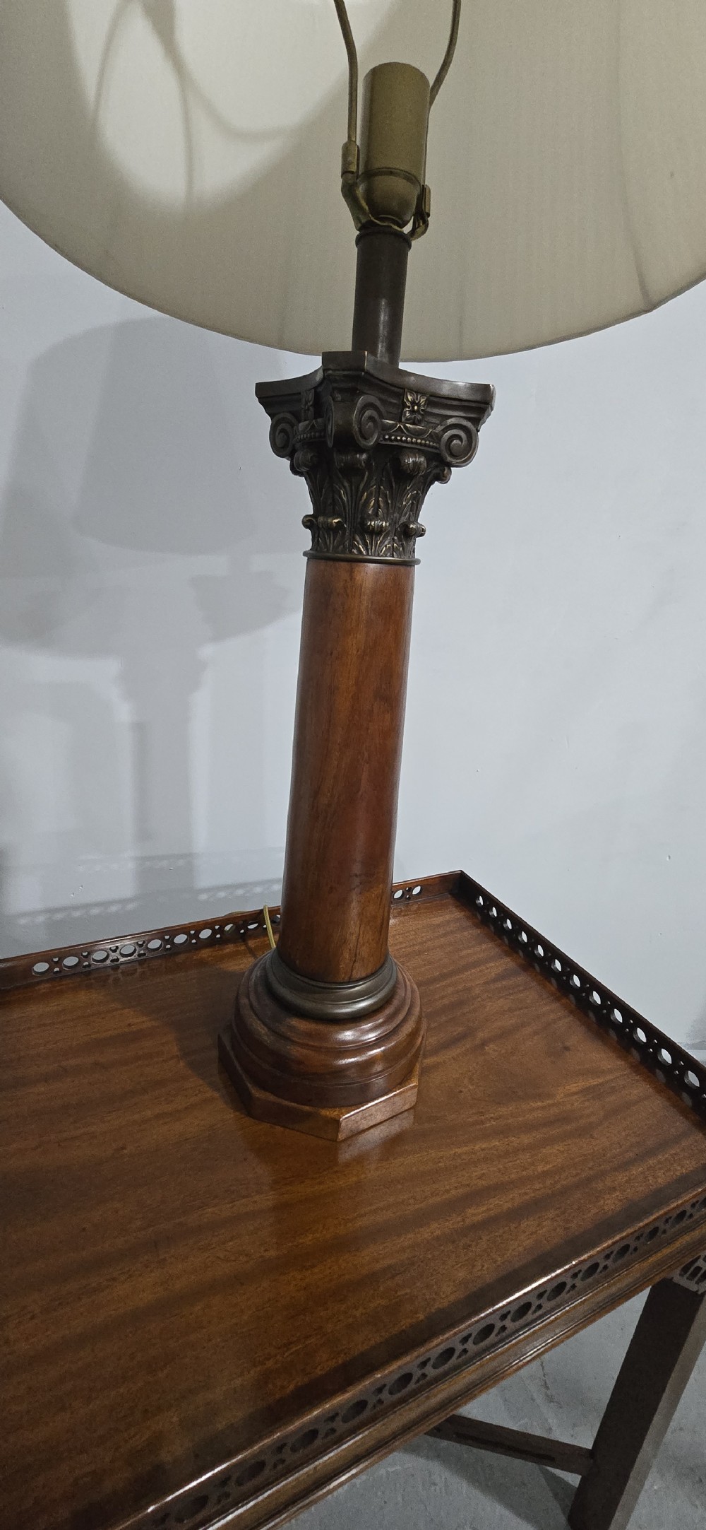 A pair of dark oak table lamps crafted in the form of Corinthian columns, topped with pleated white shades. View V