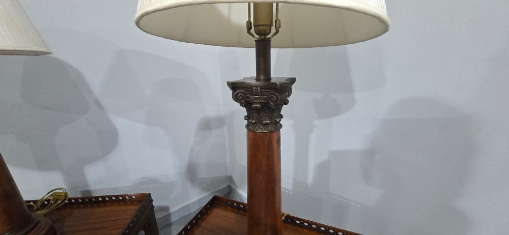 A pair of dark oak table lamps crafted in the form of Corinthian columns, topped with pleated white shades. View VI