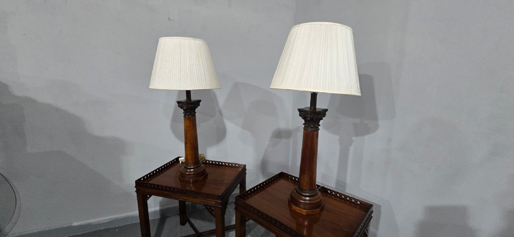 A pair of dark oak table lamps crafted in the form of Corinthian columns, topped with pleated white shades. View VIII