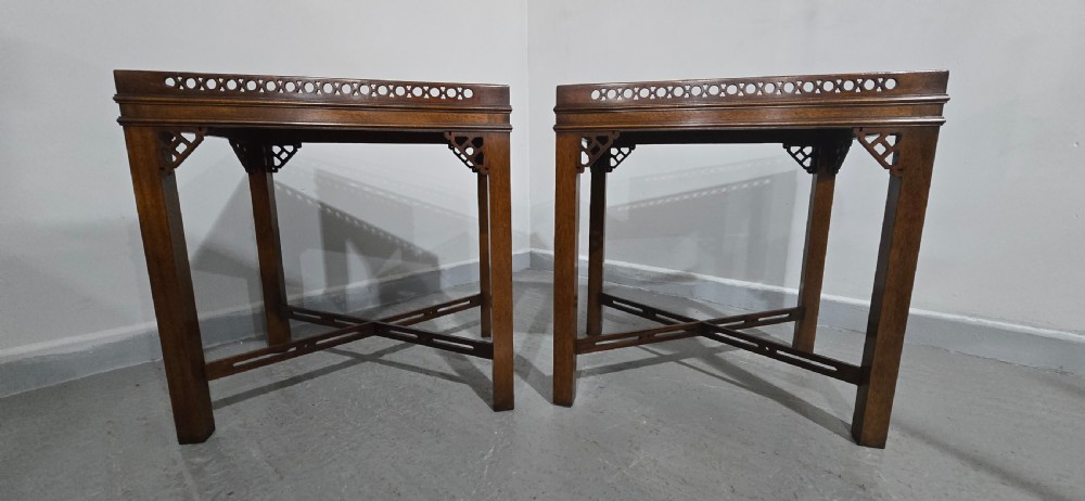 A matching pair of dark mahogany Chippendale-style lamp tables featuring pierced fretwork galleries, corner brackets, and X-frame stretchers. View IV