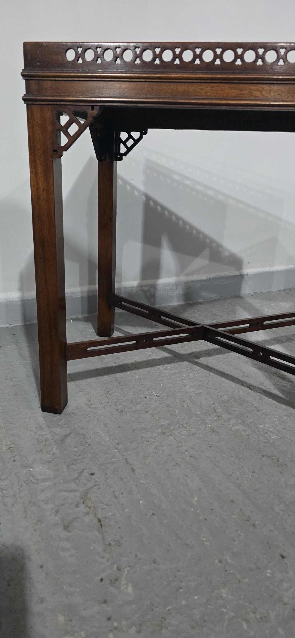 A matching pair of dark mahogany Chippendale-style lamp tables featuring pierced fretwork galleries, corner brackets, and X-frame stretchers. View V