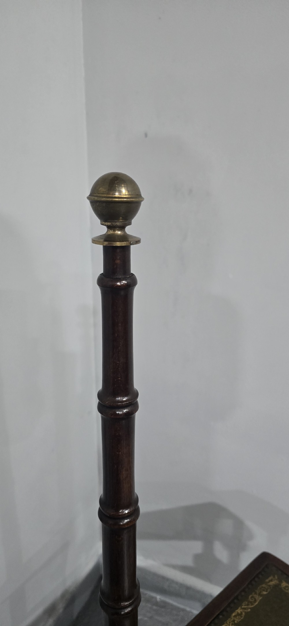 A set of four dark mahogany spiral library steps with green leather inset treads and a tall pole topped with a brass finial. View VII