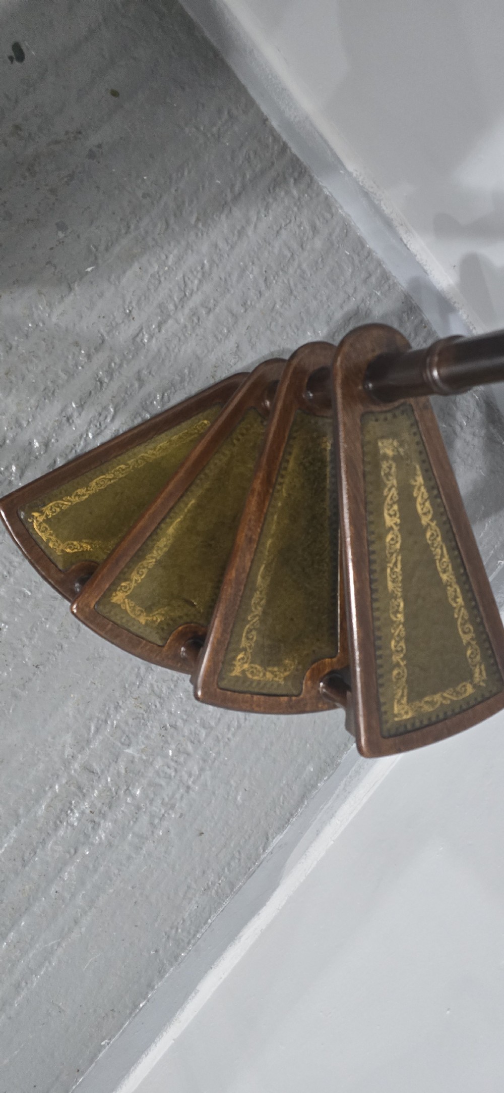 A set of four dark mahogany spiral library steps with green leather inset treads and a tall pole topped with a brass finial. View VIII