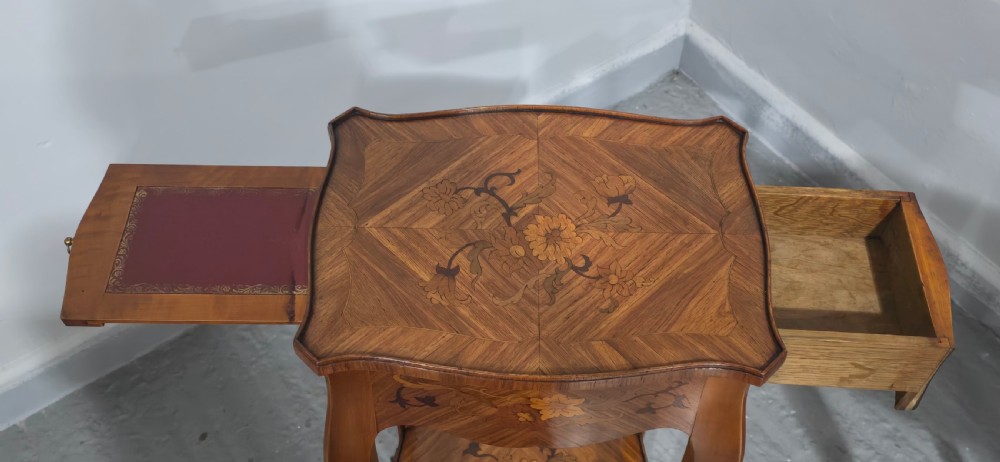 A pair of slender warm brown French marquetry tables featuring floral inlays, cabriole legs, lower shelves, and extended side drawers. View IV