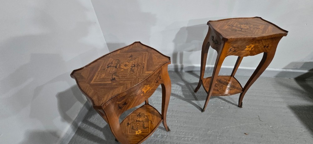 A pair of slender warm brown French marquetry tables featuring floral inlays, cabriole legs, lower shelves, and extended side drawers. View IX