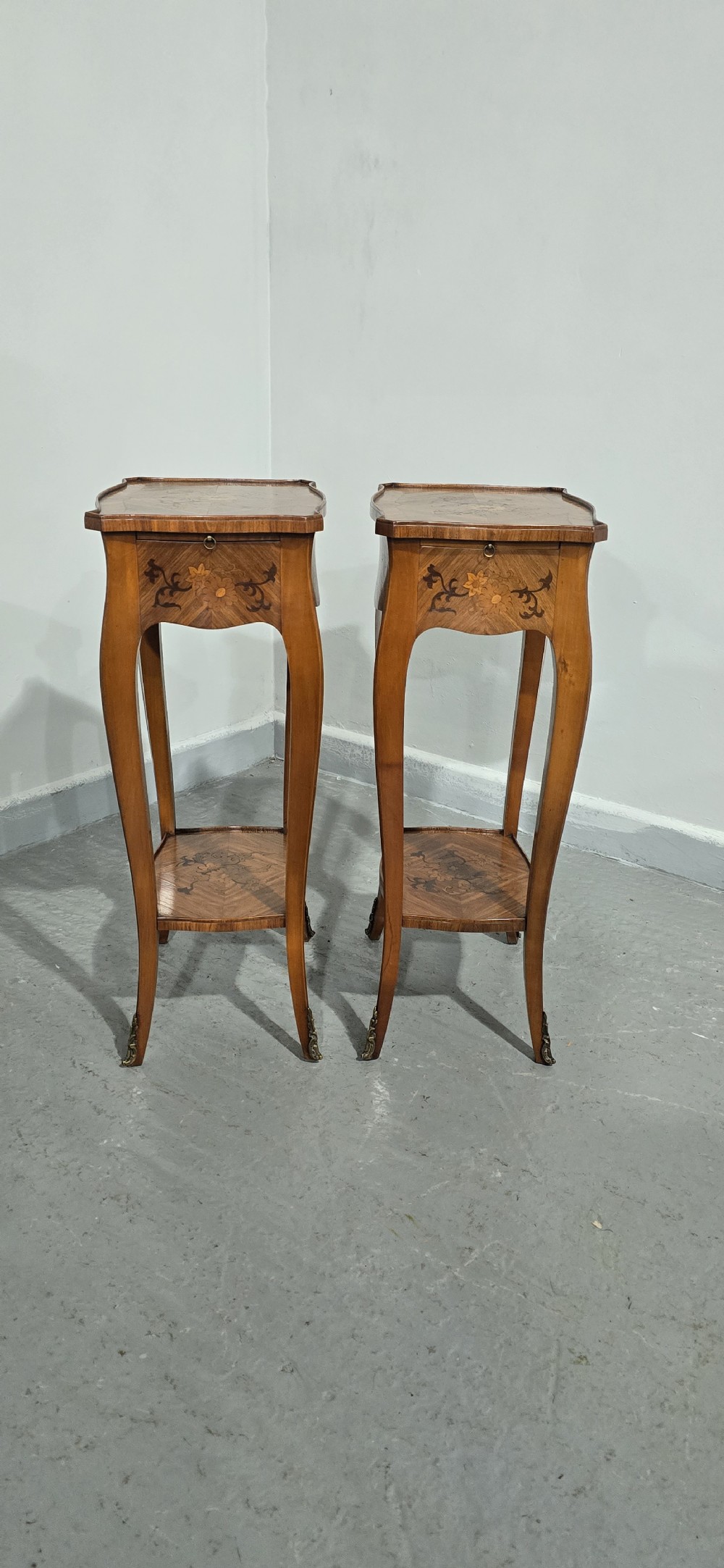A pair of slender warm brown French marquetry tables featuring floral inlays, cabriole legs, lower shelves, and extended side drawers. View XI