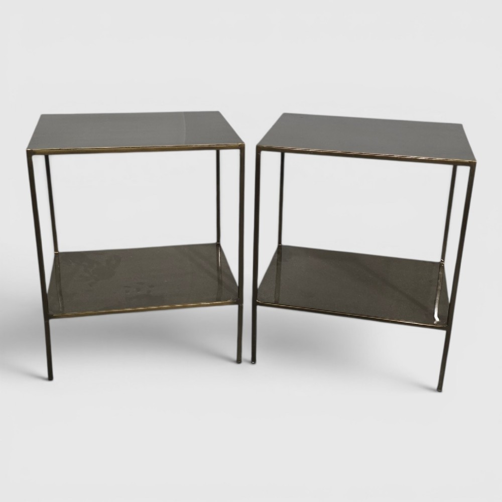 A pair of rectangular dark bronzed metal lamp tables featuring slender square legs and an integrated lower tier shelf.