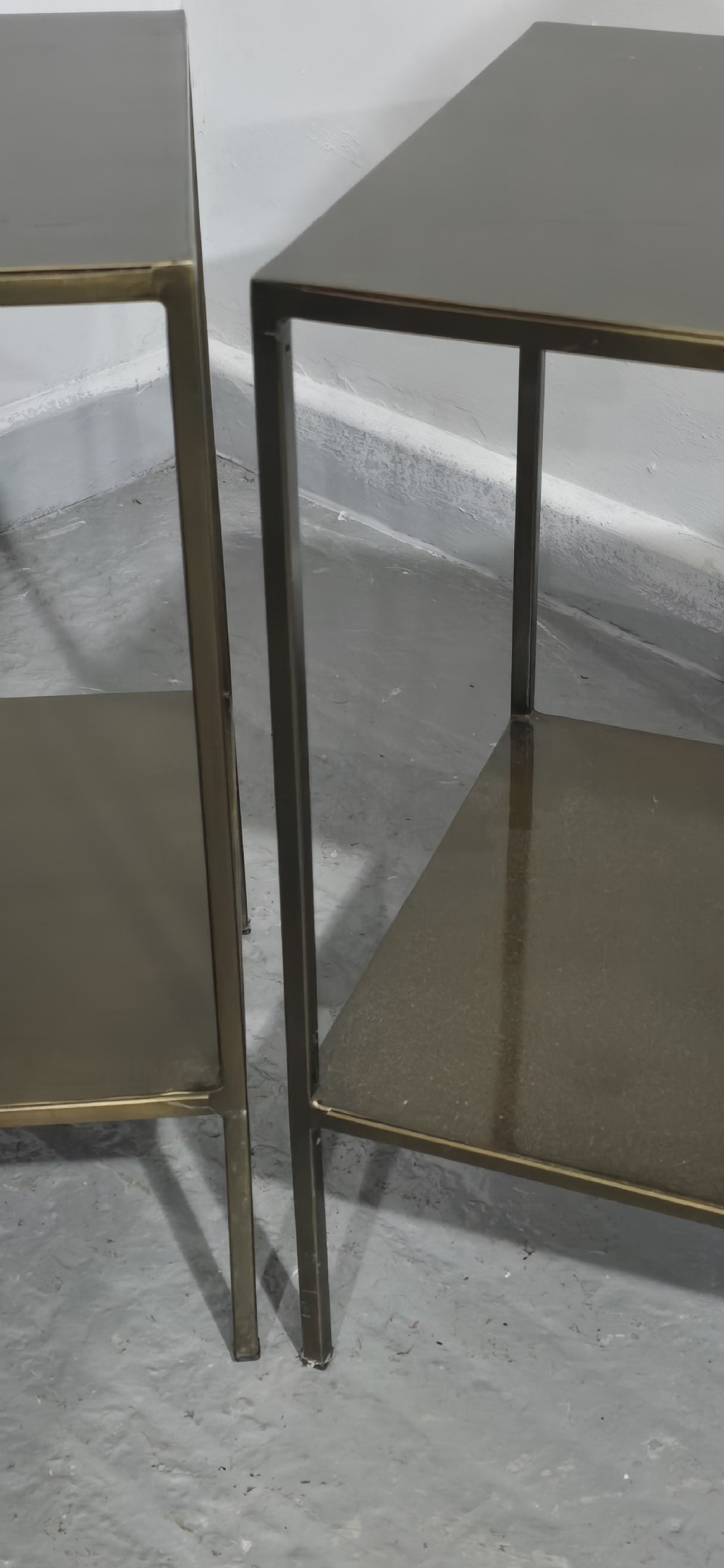 A pair of rectangular dark bronzed metal lamp tables featuring slender square legs and an integrated lower tier shelf. View VII