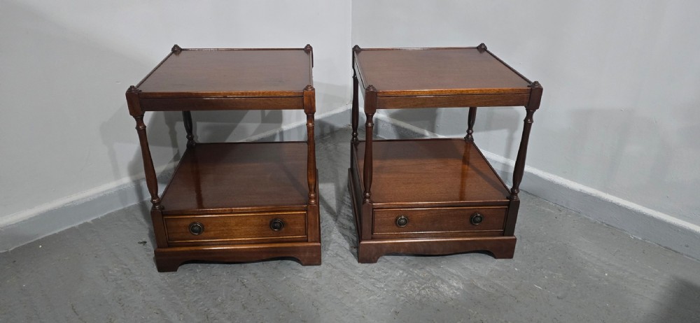 A pair of dark mahogany two-tier lamp tables with turned corner supports and single base drawers featuring brass ring handles. View IV