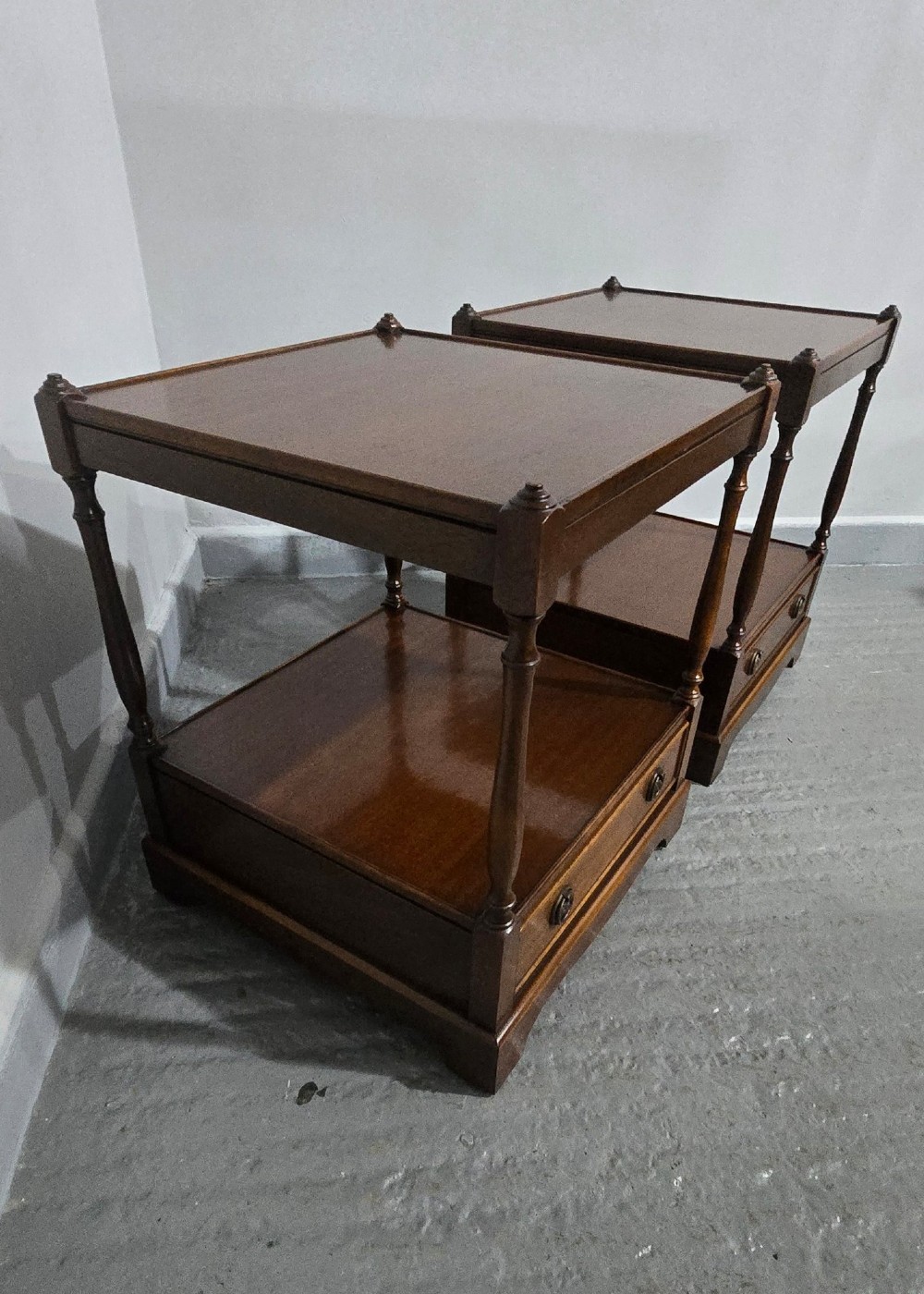 A pair of dark mahogany two-tier lamp tables with turned corner supports and single base drawers featuring brass ring handles. View IX