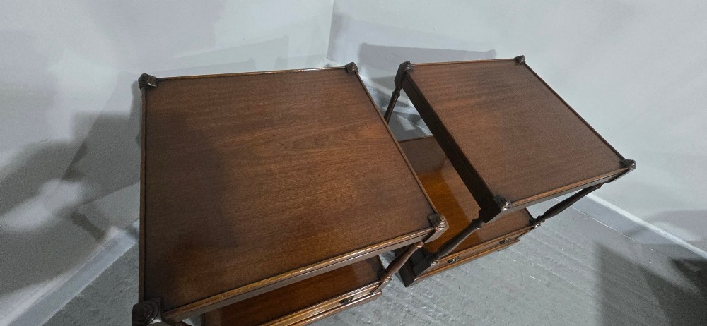A pair of dark mahogany two-tier lamp tables with turned corner supports and single base drawers featuring brass ring handles. View X