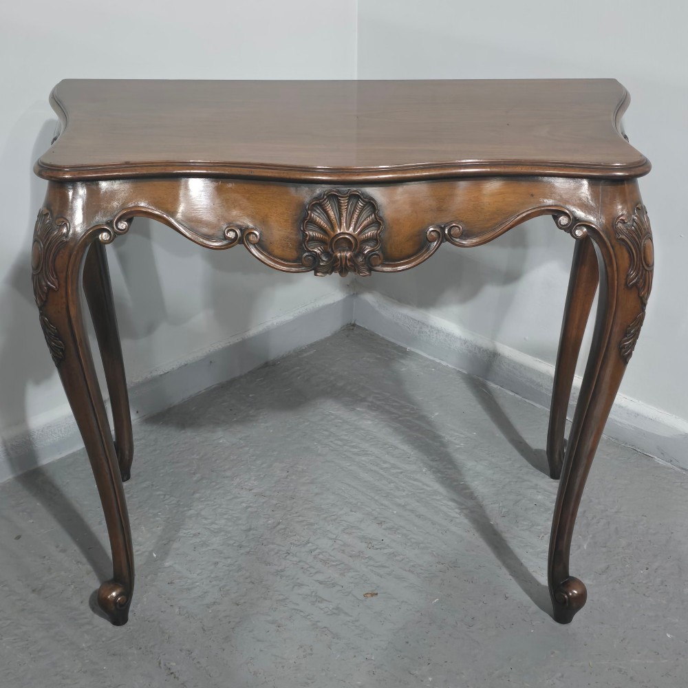 A dark mahogany console table featuring a shaped serpentine top, a central shell carving on the apron, and four cabriole legs. View II