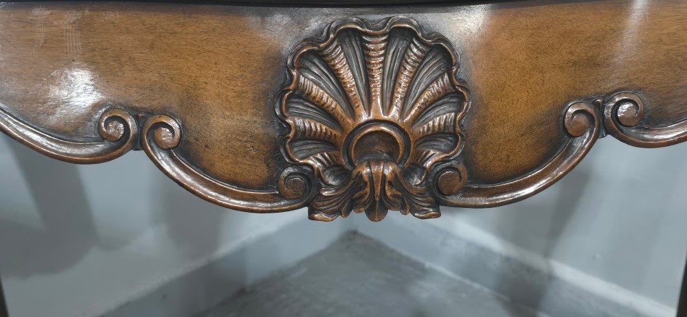 A dark mahogany console table featuring a shaped serpentine top, a central shell carving on the apron, and four cabriole legs. View V