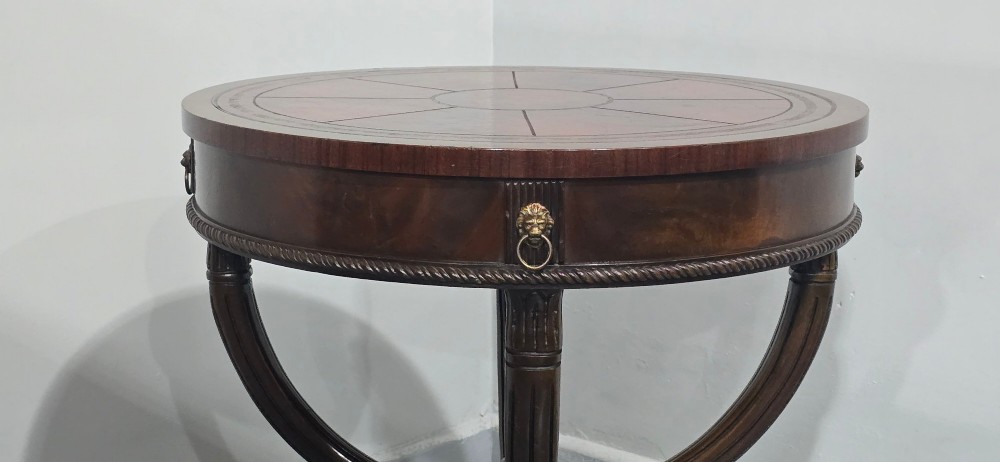 A circular mahogany occasional centre table with a segmented veneered top, brass lion mask handle, and curved reeded legs. View VII