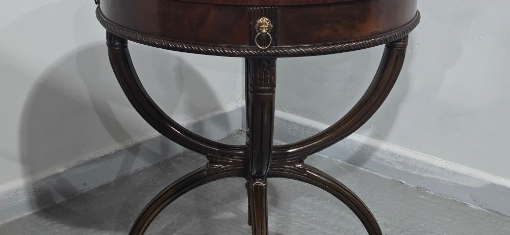 A circular mahogany occasional centre table with a segmented veneered top, brass lion mask handle, and curved reeded legs. View IX