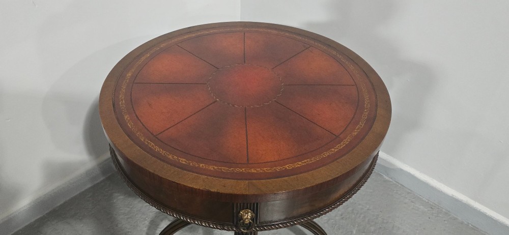 A circular mahogany occasional centre table with a segmented veneered top, brass lion mask handle, and curved reeded legs. View X